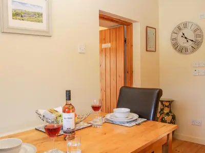 a table with a bottle of wine and a chair at Stiperstones View in Shrewsbury