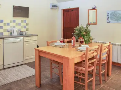 a kitchen with a wooden table and chairs at Cranberry Cottage in Shrewsbury