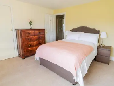a bedroom with a large bed and a dresser at Squires Rest in Welshpool