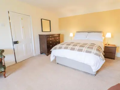 a bedroom with a bed and a dresser with two lamps at Squires Rest in Welshpool