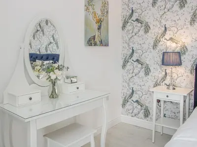 a bedroom with a dressing table and a mirror at Hillside Lodge in Ludlow