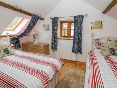 a bedroom with two beds and a window at Felin Iago in Aberystwyth