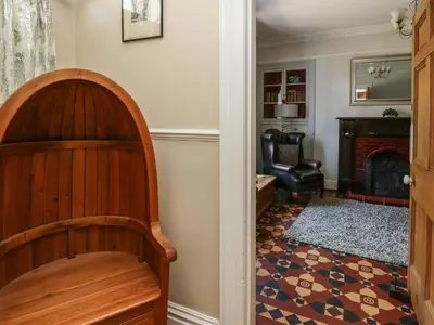a living room with a chair and a fireplace at Dewi Villa in Aberaeron
