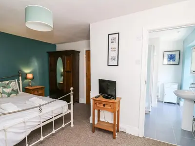 a bedroom with a bed and a tv on a table at Dewi Villa in Aberaeron