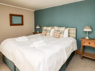 a bedroom with a large white bed with two towels on it at Dewi Villa in Aberaeron