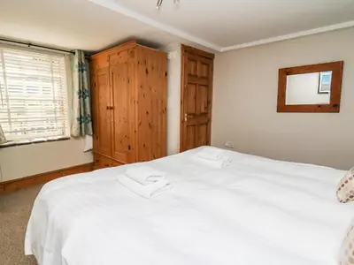 a bedroom with a large white bed and a window at Dewi Villa in Aberaeron