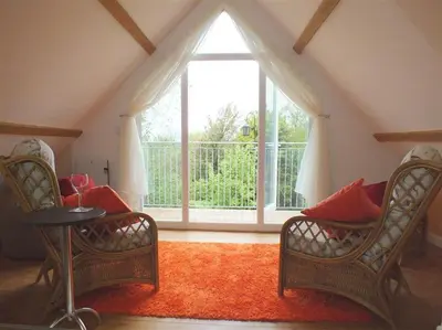 a living room with two chairs and a large window at Pond Cottage in New Quay
