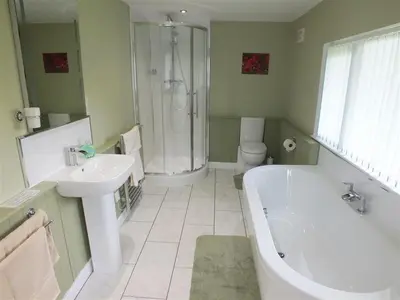 a bathroom with a tub and a toilet and a sink at Pond Cottage in New Quay