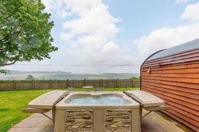 a hot tub in a yard next to a fence at Stiperstones Pod in Shrewsbury