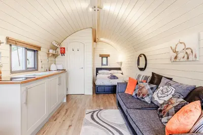 a living room with a couch and a bedroom at Corndon Pod in Shrewsbury