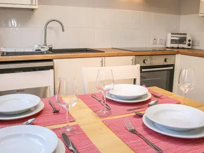 a table with plates and wine glasses on it at The Little Dingle in Church Stretton