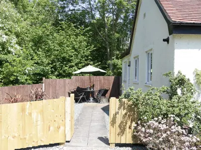 a backyard with a fence and an umbrella at The Little Dingle in Church Stretton