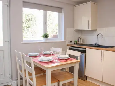 a kitchen with a table and chairs in a kitchen at The Little Dingle in Church Stretton