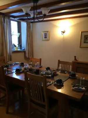 a dining room table with chairs and a long wooden table at TAN Y GRAIG in Meifod