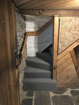 a set of stairs in a building with a wooden door at Gellibant Cottage in Llanbedr