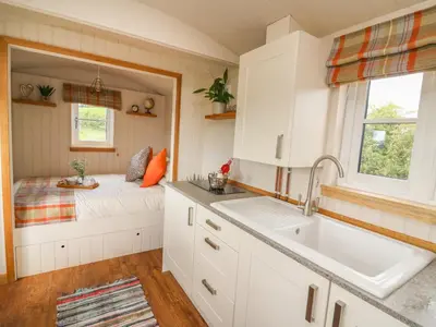 a kitchen with a sink and a bed in a room at Marches Way in Rhayader