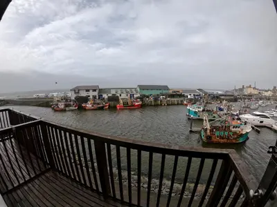 a group of boats are docked in a harbor at 46 Y Lanfa in Aberystwyth