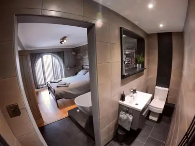 a small bathroom with a bed and a sink at 46 Y Lanfa in Aberystwyth