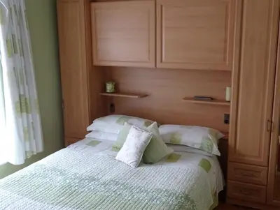 a bedroom with a bed with a cabinet above it at Beechwood House in New Quay