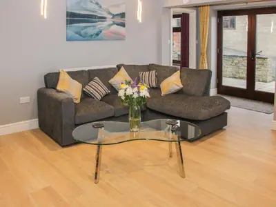 a living room with a couch and a glass table at Alders View Coach House in Craven Arms