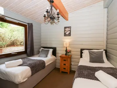 two beds in a room with a window at Sunny View in Rhayader