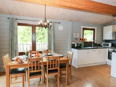 a kitchen and dining room with a wooden table and chairs at Sunny View in Rhayader
