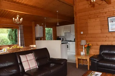 a living room with a couch and a kitchen at Hillside View in Rhayader