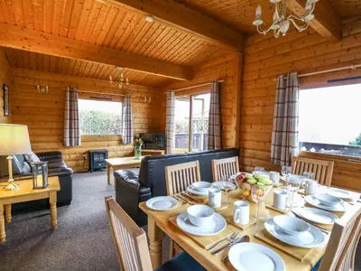 a dining room with a table and chairs and a living room at Valley View in Rhayader
