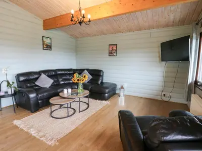 a living room with a black leather couch and a table at Mountain View in Rhayader