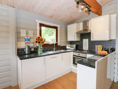 a kitchen with white cabinets and a window at Mountain View in Rhayader