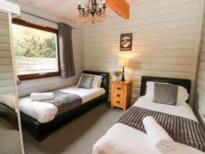 two beds in a room with a window at Mountain View in Rhayader