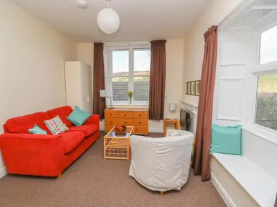 a living room with a red couch and a table at Garden View in Kington