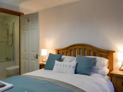 a bedroom with a bed with blue and white pillows at Hoot House in Abergynolwyn