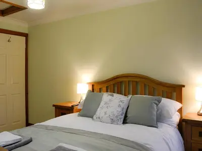 a bedroom with a bed with two lamps on two tables at Hoot House in Abergynolwyn