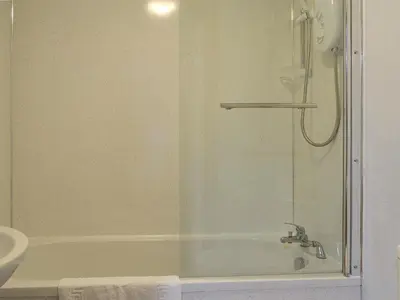 a bathroom with a shower and a tub and a sink at Hoot House in Abergynolwyn