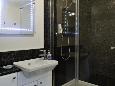 a bathroom with a sink and a glass shower at Hoot House in Abergynolwyn