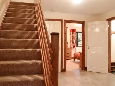 a staircase in a living room with a bedroom at Hoot House in Abergynolwyn