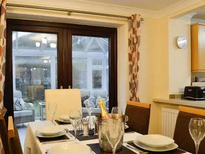 a dining room with a table with plates and glasses at Hoot House in Abergynolwyn
