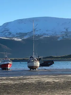 two boats are parked on a beach near the water at Aelfor Cozy Cottage in Barmouth