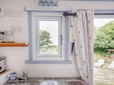 a kitchen with a sink and a window at The Shepherd's Hut in Aberdyfi