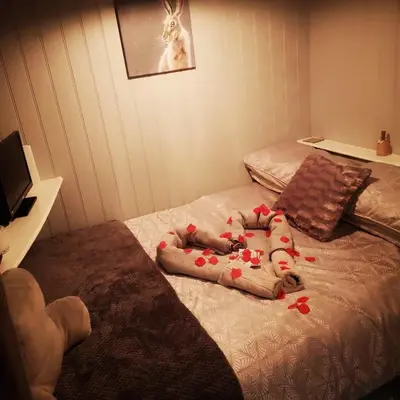 a baby laying on a bed with red peppers at pen-rhos luxury glamping 