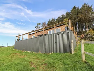 a house on top of a hill with a fence at Haka Lodge in Aberystwyth