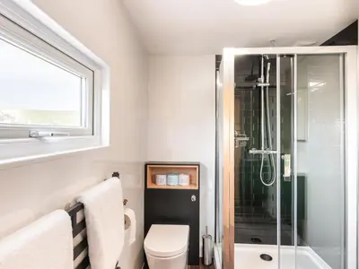 a bathroom with a toilet and a glass shower at Haka Lodge in Aberystwyth