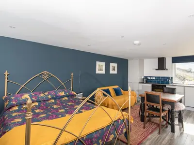 a bedroom with two beds and a blue wall at Haka Lodge in Aberystwyth