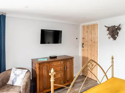 a bedroom with a bed and a tv on a wall at Haka Lodge in Aberystwyth