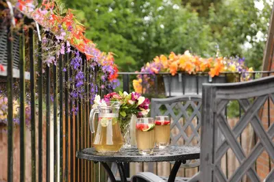 a table with drinks and flowers on a fence at Oakland Cottage in Craven Arms