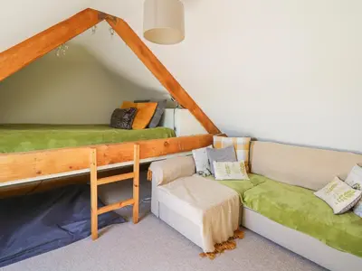 a living room with a couch and a bed at Yr Hen Beudy in Aberystwyth