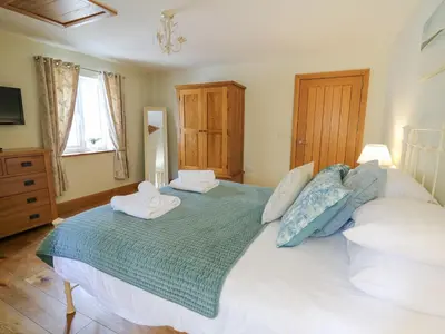 a bedroom with a large bed with two towels on it at Yr Hen Beudy in Aberystwyth