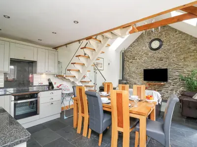 a kitchen and dining room with a wooden table and chairs at Yr Hen Beudy in Aberystwyth