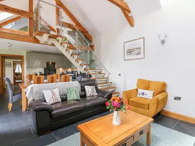 a living room with a couch and a table at Yr Hen Beudy in Aberystwyth